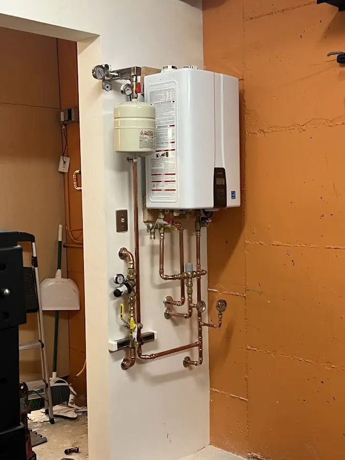 Plumbing technician inspecting water heater connections in San Marcos